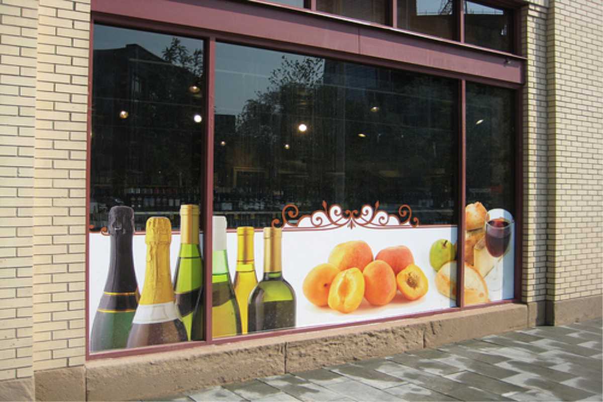 large format digital printing in window of wine shop with bottles and fruit