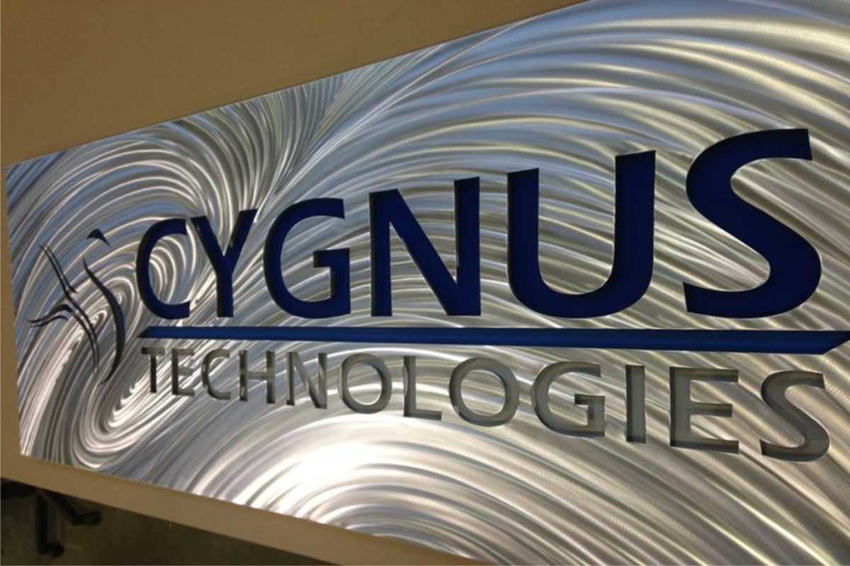 Acrylic office sign example for "Cygnus technologies" with logo, lettering and stylized background